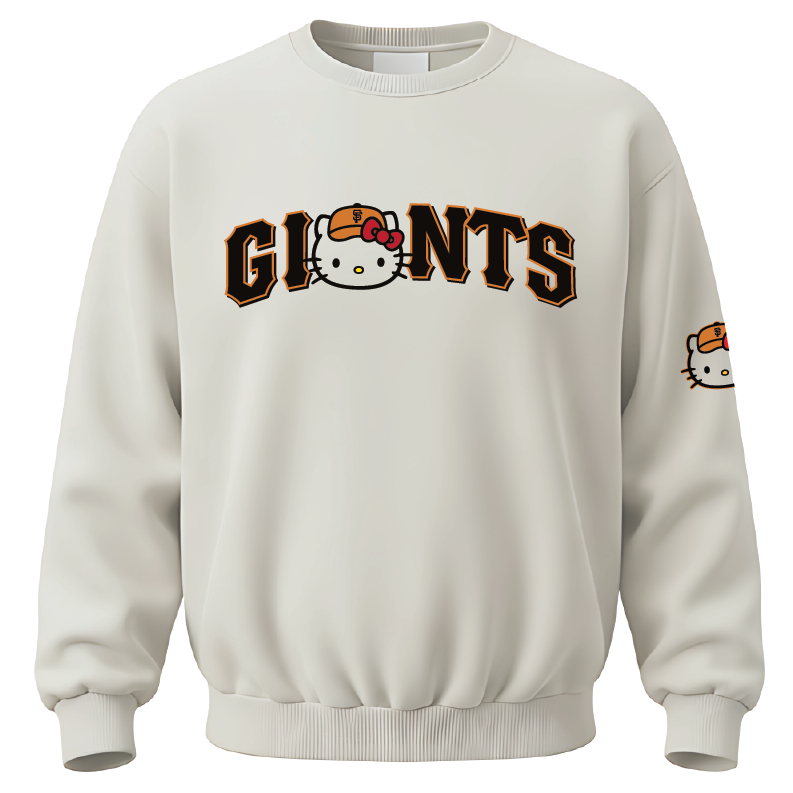 An off-white crewneck sweatshirt featuring a 'GIANTS' graphic across the chest with the Hello Kitty character integrated into the lettering, and a smaller Hello Kitty graphic on the left sleeve.