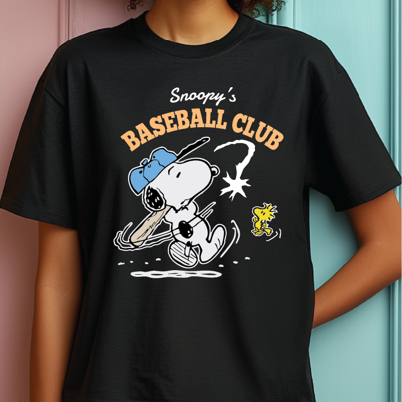 A person wearing a black graphic T-shirt featuring Snoopy and Woodstock with the text 'Snoopy's BASEBALL CLUB'